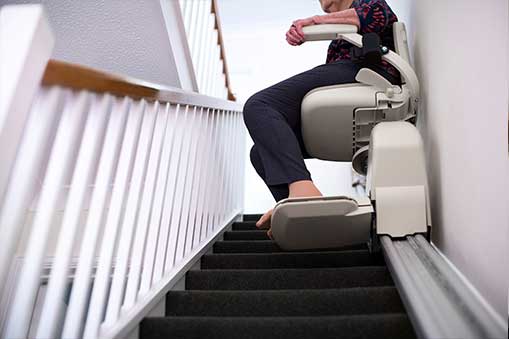 woman riding up chairlift after Stairlift Maintenance and Service in Montgomery County