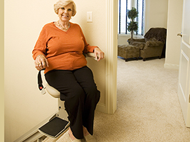 woman riding a Bruno and Harmar Stairlift for Sale in Olney, MD​