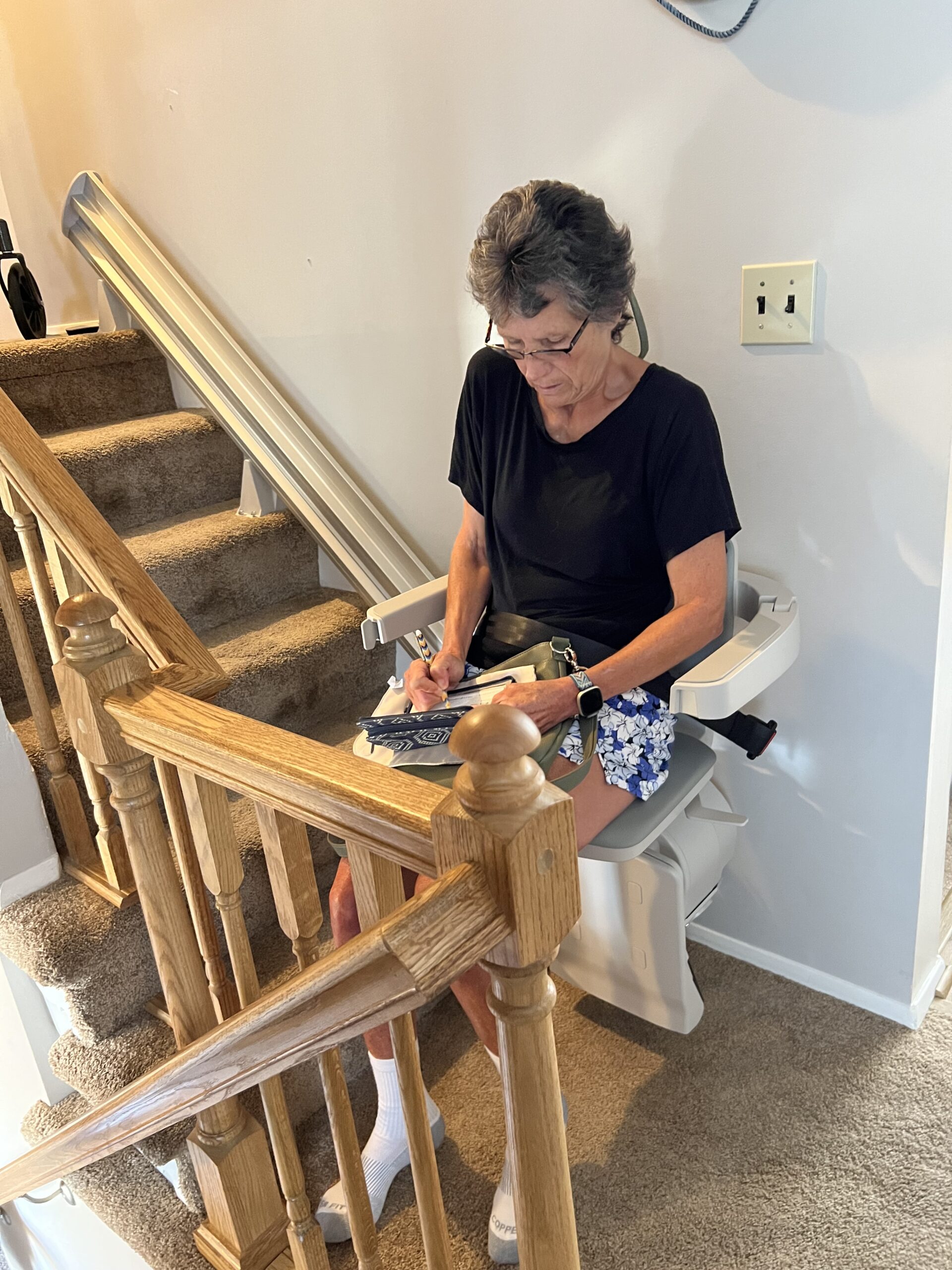 Woman using chair lift right after stairlift installation in Owings Mills, MD